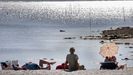 Personas tomando sol en la playa.