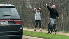 Unos viandantes reaccionan al paso del convoy que lleva a Trump al campo de golf