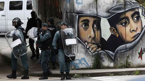 Efectivos de la Guardia Civil retiran una pancarta que cortaba el acceso al centro de la localidad de Alsasua colocada tras la detenci�n esta ma�ana por orden de la Audiencia Nacional de cuatro condenados por la agresi�n a dos guardias civiles y sus parejas en dicha localidad navarra