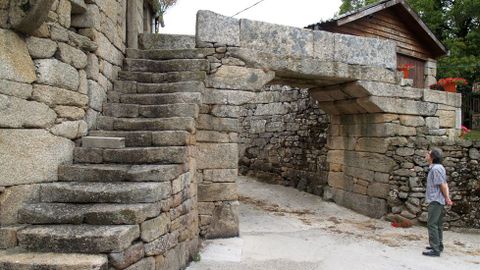 Un arco de bloques de pedra atravesa a vía principal de San Mamede