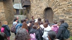 Los estudiantes observan el arco de la puerta de una vivienda de la aldea de Seceda construida con rocas del perodo Devnico