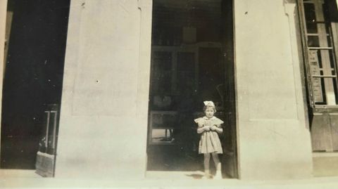 Paula Marcos, hija del matrimonio fundador, de ni�a delante de la confiter�a