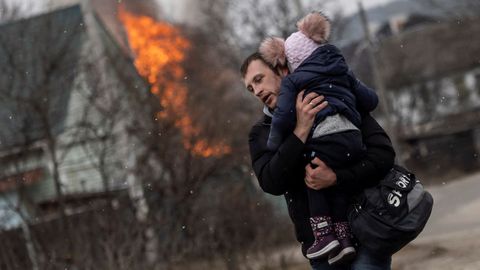 Un hombre y su hija huyendo de Irpin, despus de que la artillera rusa destruyese viviendas particulares