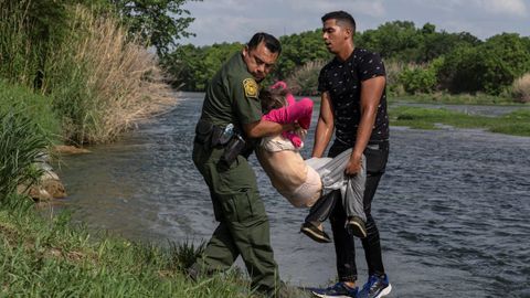 Un agente atiende al joven y a la mujer de avanza edad tras llegar a tierra