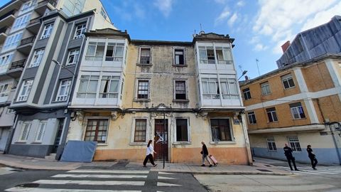 Entrada del inmueble okupado precintada tras el incendio y dos agentes del 091 vigilando que nadie entre