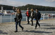 Un grupo de turistas en Carril, frente a Cortegada, una de las joyas de la capital arousana. 