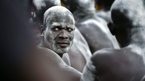 Un luchador sudans cubierto con tiza espera el momento de su prueba en Juba.