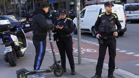 Agentes de la Guardia Urbana de Barcelona denuncian a un usuario de patinete elctrico por circular por la acera