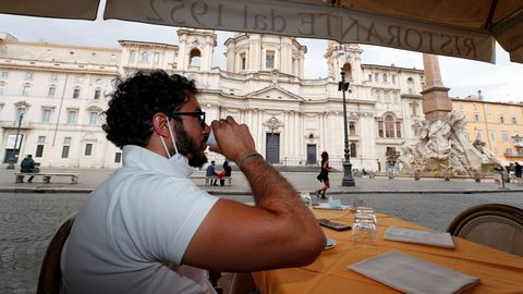 Un hombre toma un caf� en la Piazza Navona de Roma