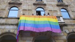 Concejales de IU y Podemos y representantes de XEGA cuelgan una bandera arcoíris en el Ayuntamiento de Gijón