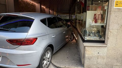 El coche se empotró contra la tienda al intenter acceder al aparcamiento