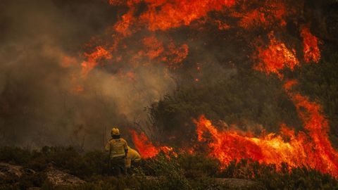 Los bomberos trabajando este domingo en la extinción del incendio forestal en el Parque Natural de Alvao, en el distrito luso de Vila Real.