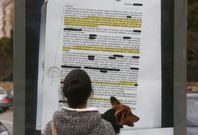 Una mujer lee una de las denuncias reales que se han llevado a vallas publicitarias de la ciudad. 