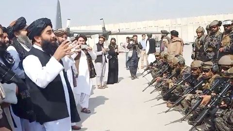 Miembros de la unidad militar montando guardia mientras el portavoz talibn pronuncia su discurso