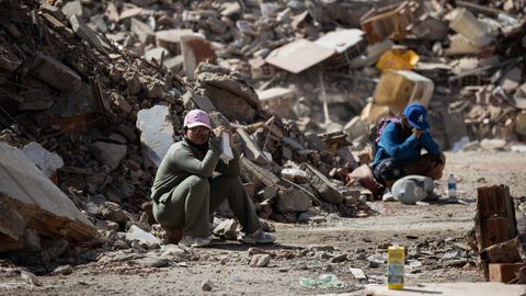 Varias personas en La Guaira junto a los escombros provocados por el derrumbe de edificios tras el doble terremoto en Venezuela