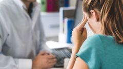 Una mujer sufriendo dolor de cabeza o migra�a en el puesto de trabajo.