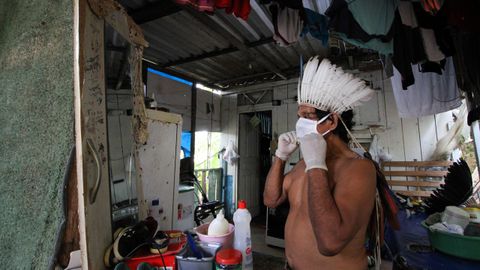 En Manaos, Brasil, un indgena se prueba ante el espejo una mascarilla protectora