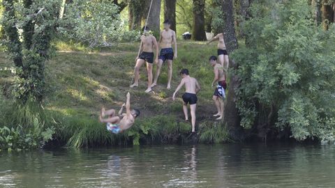 Calor y baistas en la playa fluvial de Chain, en el Tambre