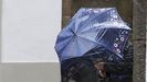Una mujer se protege en Santiago del fuerte viento durante un d�a de temporal