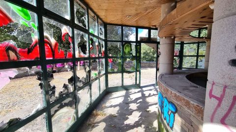 Mirador del Miño. Interior de la cafetería que llegó a funcionar hasta hace dos décadas en la zona más próxima a la pasarela que cruza la N-6. Tanto el interior como el exterior está lleno de maleza, cristales y mobiliario destrozado, además de zonas okupadas