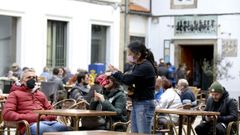 Una camarera atiende a un cliente en una terraza de Santiago