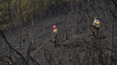 Dos brigadistas en un monte arrasado cerca de la frontera entre Ourense y Zamora, este viernes.
