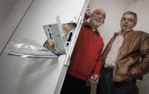 Dos vecinos muestran una cerradura reventada, en una imagen de archivo. 