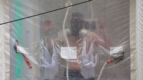 Un soldado usando la ducha especial instalada en la calle