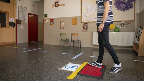 Felpudo desinfectante y pegatinas marcando itinerarios en el CEIP O Grupo de Ribeira