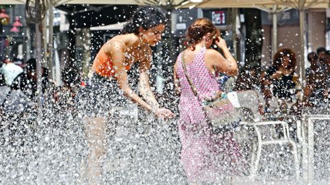 Dos mujeres se refrescan en una fuente de Pontevedra