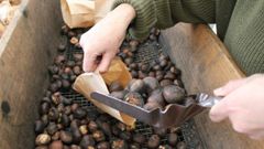 La Sociedad Protectora de La Balesquida reparte un cucurucho de castañas durante el amagüestu