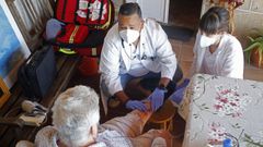 El doctor Albert Fo y la enfermera Luc�a, del centro de salud de Pi�or, atienden a una paciente en su domicilio