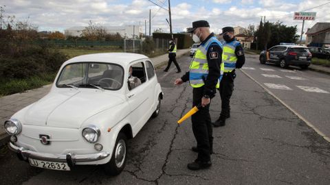 Dos polic�as locales le piden al conductor de un 600 la documentaci�n de la ITV que acaba de pasar, en un control este s�bado en la calle Ourense