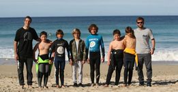 Entrenadores y participantes del Club Surf Teir�n en la arena de Razo.