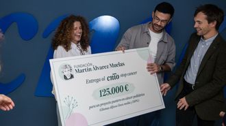 Isabel Muelas, presidenta de la fundaci&oacute;n creada en memoria de su hijo, entrega el cheque a los investigadores del CNIO Ra&uacute;l Bardini y Manuel Valiente