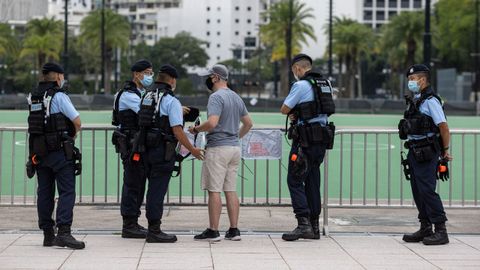 Agentes de la Polic�a de Hong Kong interroga a un viandante que fotografiaba zonas del parque Victoria.