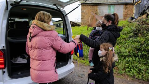 Uno de los taxis que realiza transporte escolar en Baralla recoge a dos nias en un pequeo ncleo del municipio