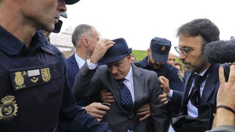 El exdirector de seguridad del ADIF, Andrés Cortabitarte, cuando fue agredido por un familiar de una víctima a la salida del juicio