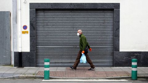 Un hombre camina con una mascarilla por una calle de Monforte