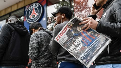 Aficionados del PSG esperan la apertura de la tienda del club en los Campos El�seos con del diario deportivo franc�s L'Equipe que titula en portada �A King in Paris� (Un rey en Par�s)