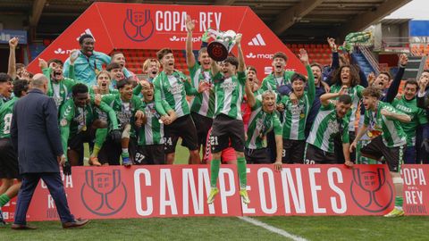 El capit&aacute;n del Betis, Corralejo, levanta el trofeo de campe&oacute;n en presencia de Rafael Louz&aacute;n, presidente de la RFEF.