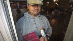 Lucas Oubi�a Fojo, con su libro y una figura, tras una cristalera del Caf� Moderno, en Pontevedra