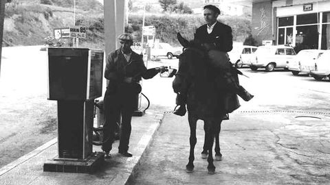 Un hombre a caballo llena un bid&oacute;n de gasolina en una estaci&oacute;n de servicio de Becerre&aacute;, en 1975