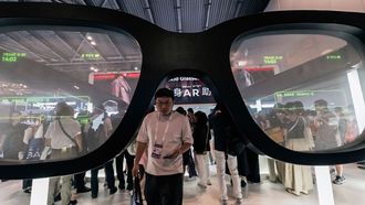 Un visitante pasa bajo una gafas inteligentes gigantes en una feria de Shangh�i, China, en julio del 2025