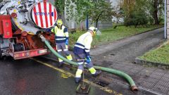Trabajadores del servicio de aguas desatascan los sumideros en la calle D�az de la Banda