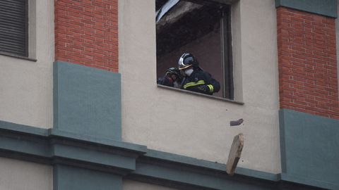 Unos bomberos lanzan escombros por una ventana prxima a la azotea del colegio San Vicente Pal