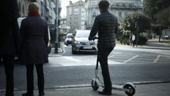 Imagen de archivo de un hombre esperando con un patinete el�ctrico
