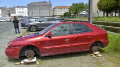 Coche abandonado y desmantelado en el barrio de A Solaina, en Nar�n, ayer al mediod�a. 
