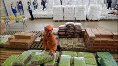 Miembros de la Defensa Civil colombiana organizan la ayuda estadounidense que se acumula en un almac�n de C�cuta