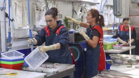 Rocío Soto, en primer término, limpiando material en su puesto, Peixes Niki.